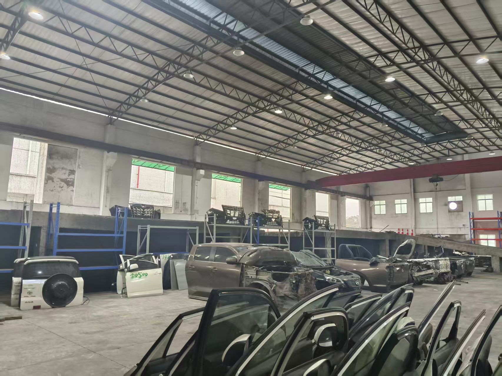 Vehicle bodies and doors inside a dismantling facility